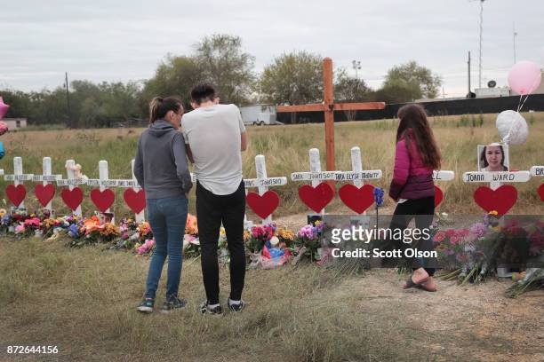 Visitors pay respects at a memorial where 26 crosses were placed to honor the 26 victims killed at the First Baptist Church of Sutherland Springs on...