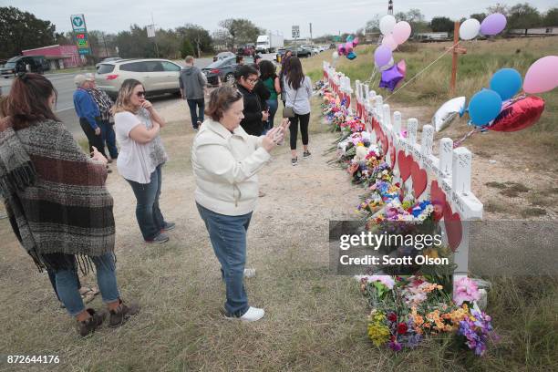 Visitors mourn the loss of family and friends at a memorial where 26 crosses were placed to honor the 26 victims killed at the First Baptist Church...