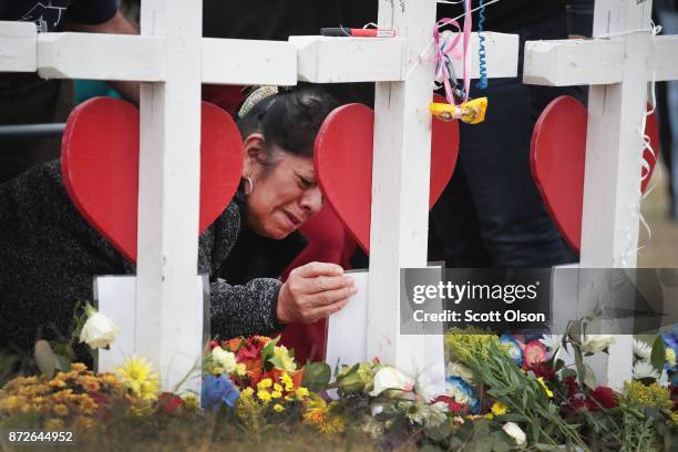 Lilly Navejan in front of a picture of her brother while visiting a memorial where 26 crosses were placed to honor the 26 victims killed at the First...