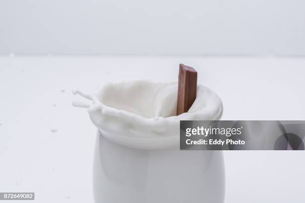 barra de chocolate salpicando al caer en vaso de leche - vaso 個照片及圖片檔
