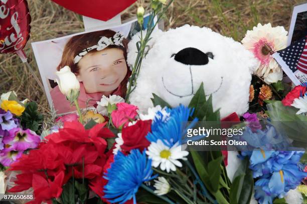 Teddy bear and a photograph lay at the foot of a cross honoring 16-year-old Haley Krueger at a memorial where 26 crosses were placed to honor the 26...