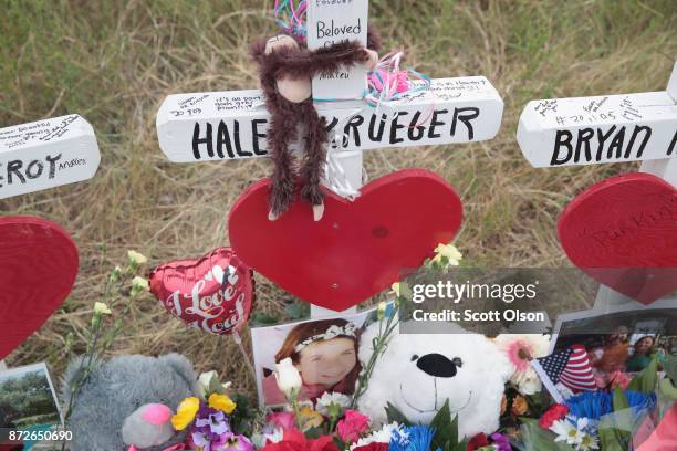 Teddy bear and a photograph lay at the foot of a cross honoring 16-year-old Haley Krueger at a memorial where 26 crosses were placed to honor the 26...