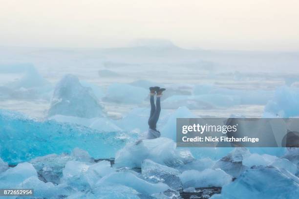 a person doing a handstand at the diamond ice beach at jokulsarlon, iceland - head in the sand stock pictures, royalty-free photos & images
