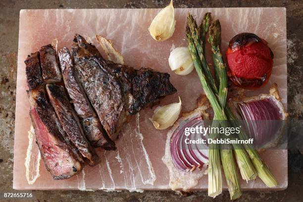 steak and vegetables on a himalayan salt block - purple garlic cloves stock pictures, royalty-free photos & images