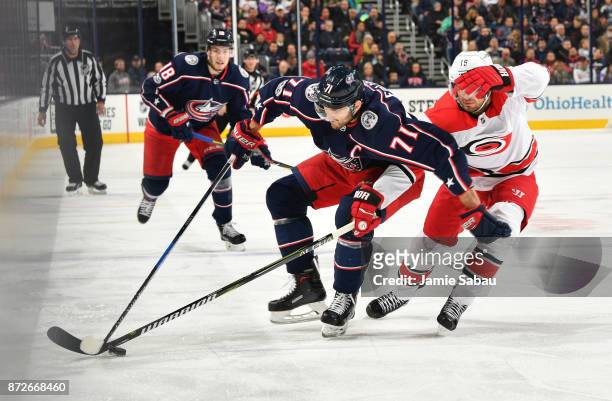 Marcus Kruger of the Carolina Hurricanes reaches to knock the puck away from Nick Foligno of the Columbus Blue Jackets during the first period of a...