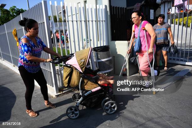 Isabel Pantoja pushes a stroller with her ten-month-old baby Luis Gonzales as they arrive at a clinic in Colima city for Luis' medical check-up, in...