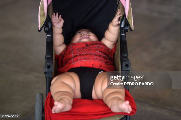 Ten-month-old baby Luis Gonzales is pictured in his stroller at a bus station in Colima city, Mexico on November 9, 2017. Luis Manuel Gonzales is...