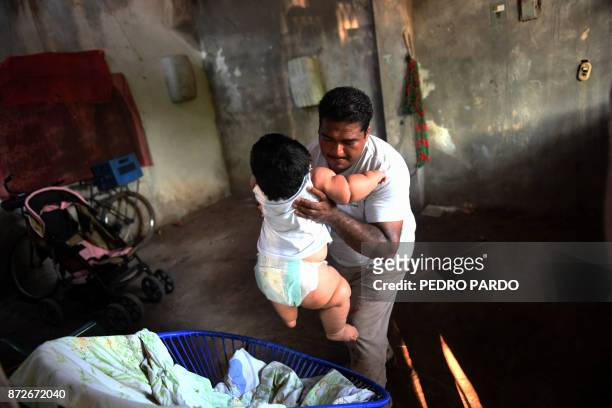 Mario Gonzales lifts his ten-month-old baby Luis at their home in Tecoman, Colima state, Mexico on November 8, 2017. Luis Manuel Gonzales is almost...