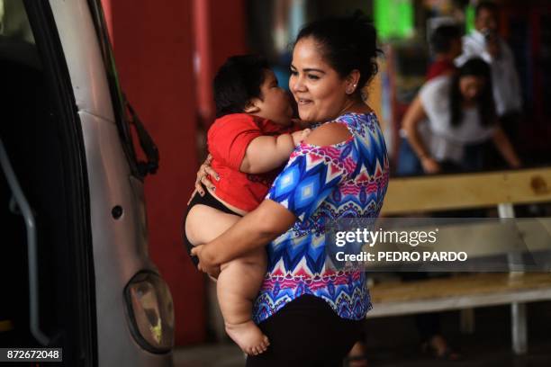 Isabel Pantoja holds her ten-month-old baby Luis Gonzales as they wait at the bus station in Colima city where they headed for Luis' medical chek-up,...
