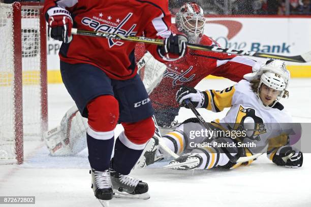 Carl Hagelin of the Pittsburgh Penguins collides with goalie Braden Holtby of the Washington Capitals during the first period at Capital One Arena on...