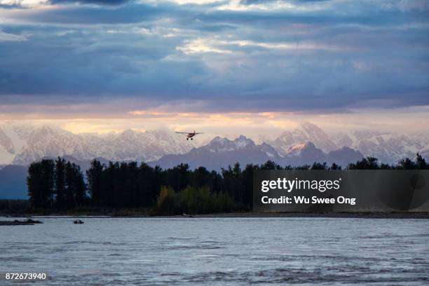 seaplane flying over alaskan range during sunset - wu swee ong stock pictures, royalty-free photos & images