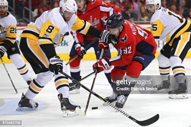 Evgeny Kuznetsov of the Washington Capitals is defended by Brian Dumoulin of the Pittsburgh Penguins during the second period at Capital One Arena on...
