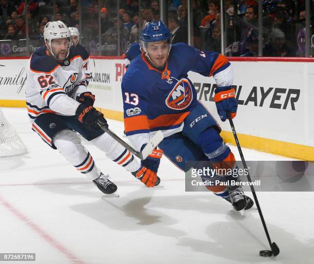 Mathew Barzal of the New York Islanders skates as Eric Gryba of the Edmonton Oilers tries to defend in an NHL hockey game at Barclays Center on...