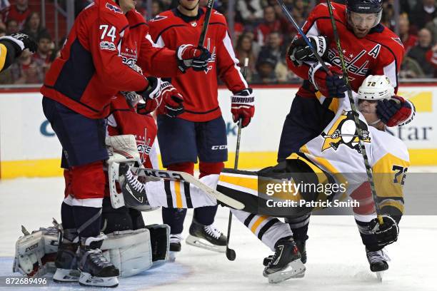 Brooks Orpik of the Washington Capitals pulls down Patric Hornqvist of the Pittsburgh Penguins during the third period at Capital One Arena on...