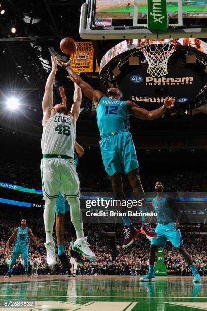 Aron Baynes of the Boston Celtics and Dwight Howard of the Charlotte Hornets jump for the rebound on November 10, 2017 at the TD Garden in Boston,...