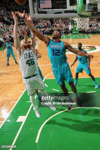 Aron Baynes of the Boston Celtics and Dwight Howard of the Charlotte Hornets jump for the rebound on November 10, 2017 at the TD Garden in Boston,...
