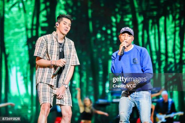 Singers Kris Wu and Pharrell Williams perform on the stage during 2017 Alibaba Singles' Day Global Shopping Festival gala at Mercedes-Benz Arena on...