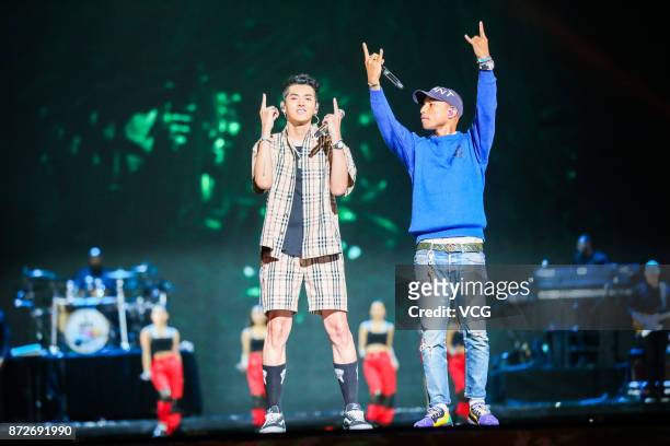 Singers Kris Wu and Pharrell Williams perform on the stage during 2017 Alibaba Singles' Day Global Shopping Festival gala at Mercedes-Benz Arena on...