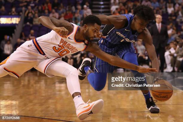 Troy Daniels of the Phoenix Suns and Jonathan Isaac of the Orlando Magic dive for a loose ball during the first half of the NBA game at Talking Stick...