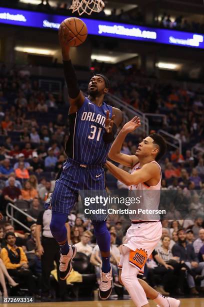 Terrence Ross of the Orlando Magic lays up a shot past Devin Booker of the Phoenix Suns during the first half of the NBA game at Talking Stick Resort...