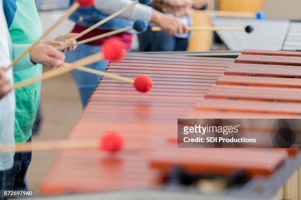 unrecognizable children play the xylophone together - xylophone stock pictures, royalty-free photos & images