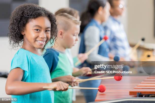 schattige kleine meisje glimlach voor de camera tijdens het spelen van de xylofoon - children music stockfoto's en -beelden