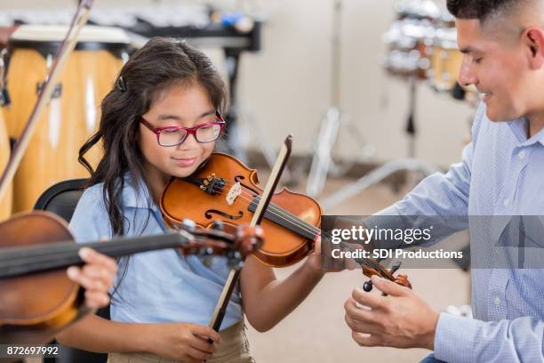 kleines mädchen erhält unterricht in violine klasse - music class stock-fotos und bilder