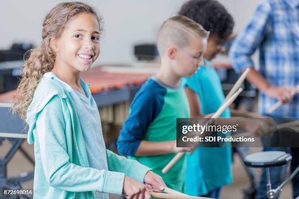 schattig klein meisje glimlacht voor camera in muziek klasse - xylofoon stockfoto's en -beelden