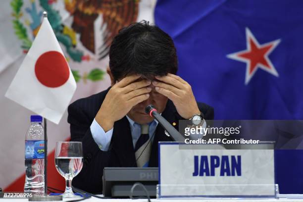 Japan's Economic Revitalization Minister Toshimitsu Motegi reacts during a Trans Pacific Partnership press conference on the sidelines of the...