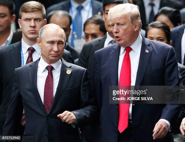 President Donald Trump and Russia's President Vladimir Putin talk as they make their way to take the "family photo" during the Asia-Pacific Economic...