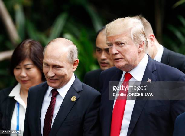 President Donald Trump and Russia's President Vladimir Putin walk together to take part in the "family photo" during the Asia-Pacific Economic...