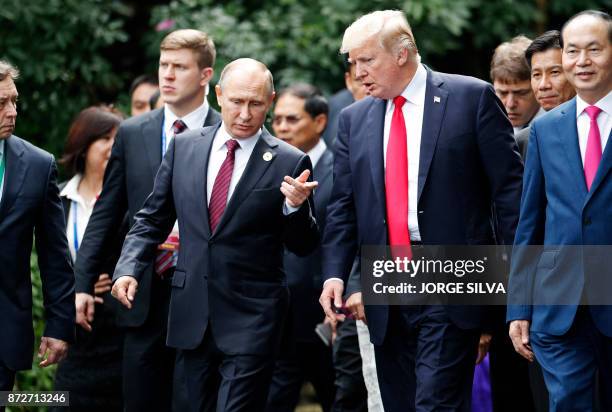 President Donald Trump and Russia's President Vladimir Putin chat as they walk together to take part in the "family photo" during the Asia-Pacific...