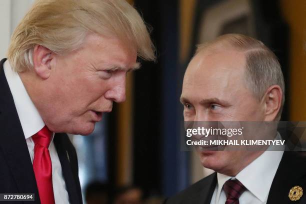 President Donald Trump chats with Russia's President Vladimir Putin as they attend the APEC Economic Leaders' Meeting, part of the Asia-Pacific...