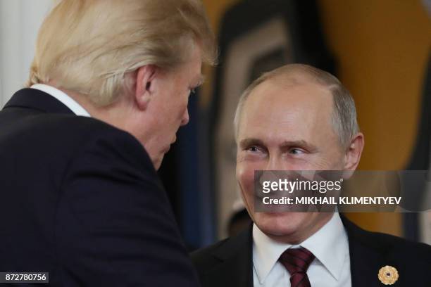 President Donald Trump chats with Russia's President Vladimir Putin as they attend the APEC Economic Leaders' Meeting, part of the Asia-Pacific...
