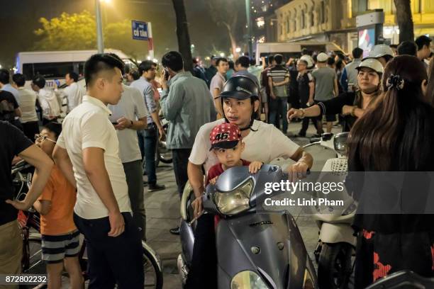 Vietnamese crowds watch as the convoy transporting U.S. President Donald Trump passes by in front of Hanoi Opera House on November 11, 2017 in Hanoi,...