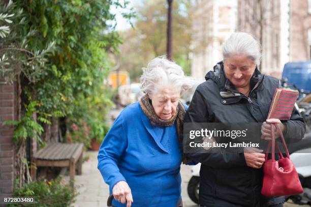 woman taking a 101-year old woman home - 100 jahre alter mensch stock-fotos und bilder