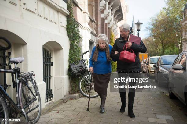 woman taking a 101-year old woman home - 55 year old woman stock-fotos und bilder