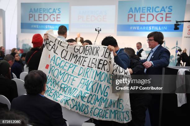 Protesters show banners at the US climate action center on November 11, 2017 during the COP23 United Nations Climate Change Conference in Bonn,...