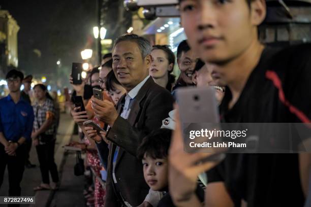 Vietnamese people gather in front of Hanoi Opera House as the convoy transporting U.S. President Donald Trump passes by on November 11, 2017 in...
