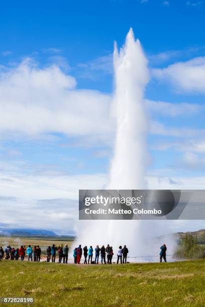 tourists watching strokkur geyser erupting, geysir, iceland - strokkur stock pictures, royalty-free photos & images