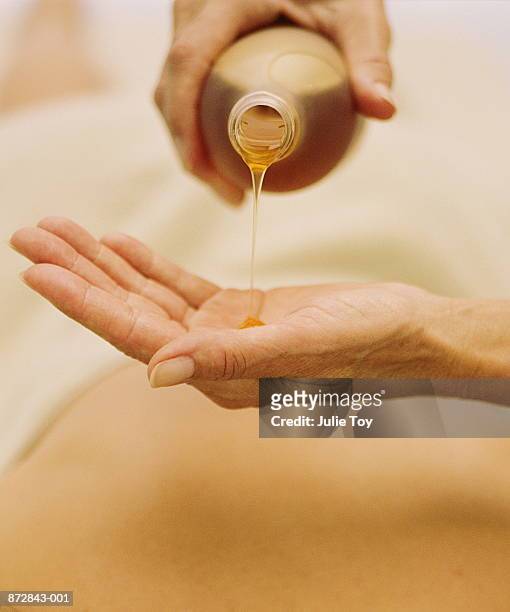 woman pouring oil on palm of hand - 按摩油 個照片及圖片檔