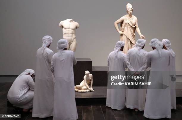 Emirati visitors look at exhibits during the opening of the Louvre Abu Dhabi Museum on November 11, 2017 on Saadiyat island in the Emirati capital.