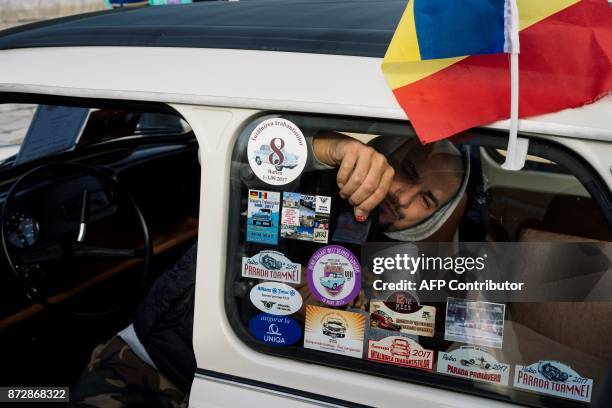 Romanian Trabant owner sticks ? sticker on his car windshield during a gathering to celebrate the 60th anniversary of the car, in the town of Pavel...