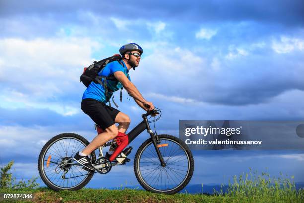 side view of mountain biker - bike headset stock pictures, royalty-free photos & images