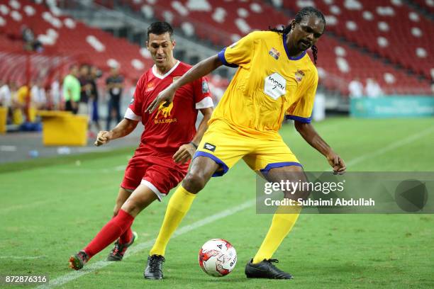 Nwankwo Kanu of Arsenal Masters shields the ball from Luis Garcia of Liverpool Masters during the Battle of the Masters at National Stadium on...