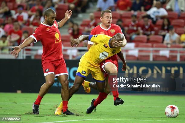 Phil Babb and Jan Kromkamp of Liverpool Masters challenge Luis Boa Morte of Arsenal Masters during the Battle of the Masters at National Stadium on...