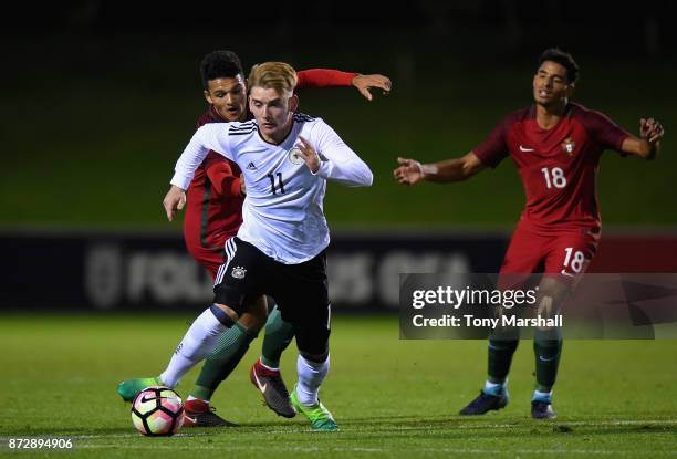 Ole Pohlmann of Germany is tackled by Goncalo Ramos of Portugal during the International Match between Germany U17 and Portugal U17 at St Georges...