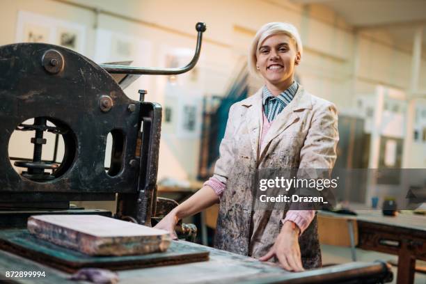 proud artist posing in her workshop near printing press - intaglio stock pictures, royalty-free photos & images