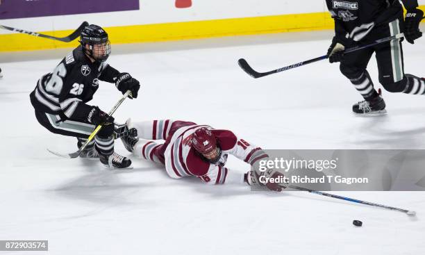 Cale Makar of the Massachusetts Minutemen is tripped by Brian Pinho the Providence College Friars during NCAA hockey at the Mullins Center on...