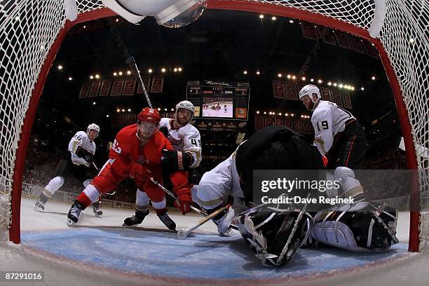 Darren Helm of the Detroit Red Wings goes hard to the net on goaltender Jonas Hiller of the Anaheim Ducks during as teamates Ryan Carter, Andrew...